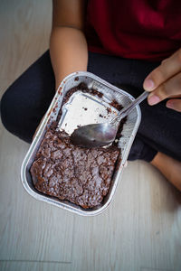 Brownies in a aluminum tray being eaten by a person. high angle view.