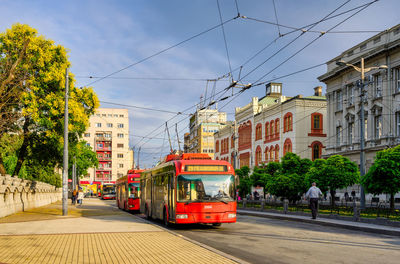 Cars on street in city against sky