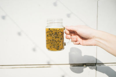 Close-up of person hand holding glass of jar