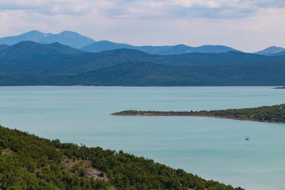 Scenic view of lake and mountains against sky