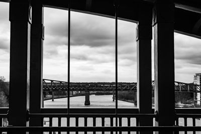 Bridge over river in city against sky