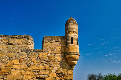 Low angle view of old ruin building against blue sky