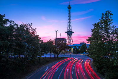 Light trails on road with berlin radio tower (funkturm) against sky