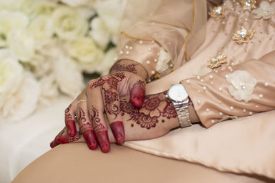 Midsection of woman with tattoo on hand