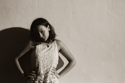 Young woman standing against wall