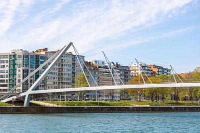 Bridge over river against buildings in city