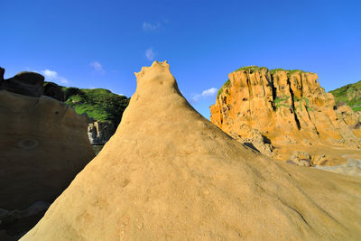 Low angle view of mountain against blue sky