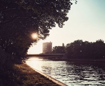 River by city against clear sky during sunset