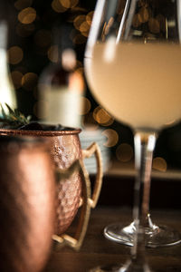 Copper mugs with rosemary sprigs and wine glasses arranged for celebration during the holidays 