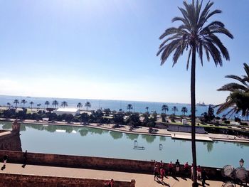 People by swimming pool against clear sky