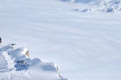 Fog above in the valley at winter in snow covered mountains