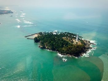 High angle view of island with lighthouse in sea