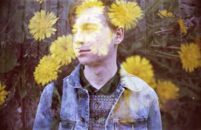 Double exposure of young man and yellow flowers