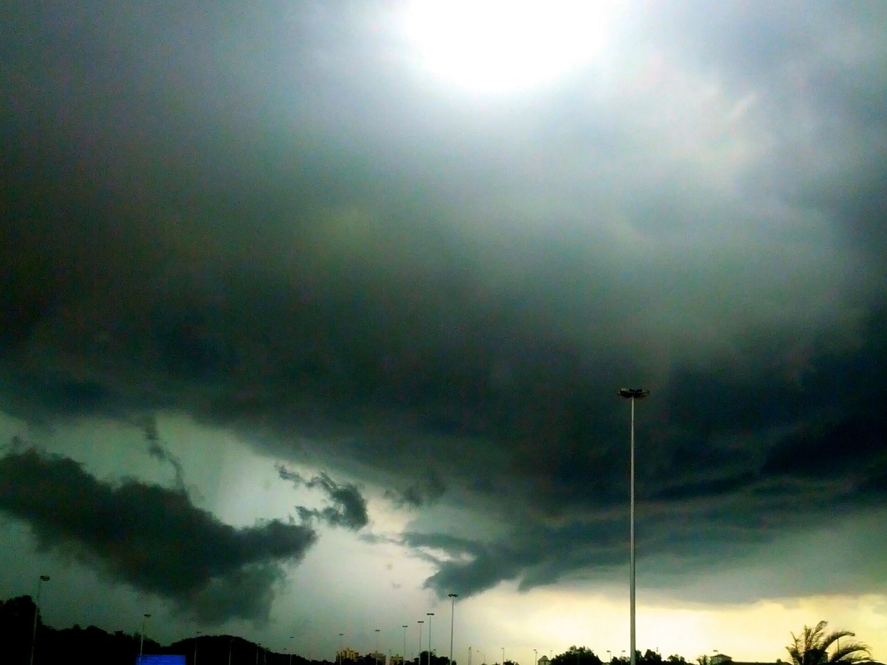 sky, cloud - sky, low angle view, cloudy, weather, overcast, storm cloud, beauty in nature, tranquility, silhouette, street light, nature, scenics, tranquil scene, dramatic sky, cloudscape, cloud, tree, atmospheric mood, outdoors