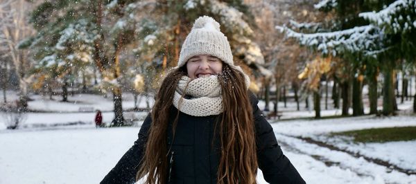 Happy woman throws snow in winter