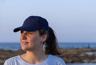 Smiling teenager wearing cat standing at beach