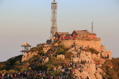 Group of people in front of temple building against clear sky