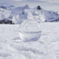 Close-up of  crystal ball on land against sky