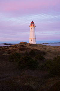 Lighthouse by sea against sky