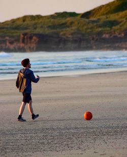 Boy playing with ball on beach