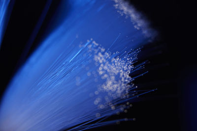 Low angle view of illuminated cables against sky at night