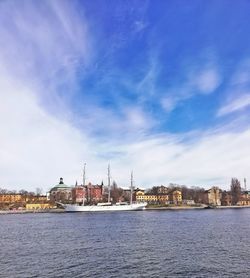 View of buildings at waterfront against cloudy sky