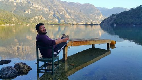 Woman sitting on pier at lake