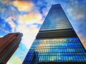 Low angle view of modern building against cloudy sky