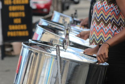 A few people playing music with steelpans on the streets practicing for carnival 