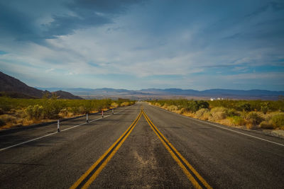 Road passing through landscape against sky