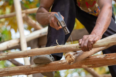 Midsection of man working on wood