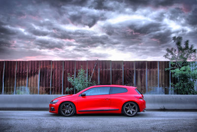 Car on road against cloudy sky