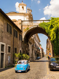 Cars on road amidst buildings against sky