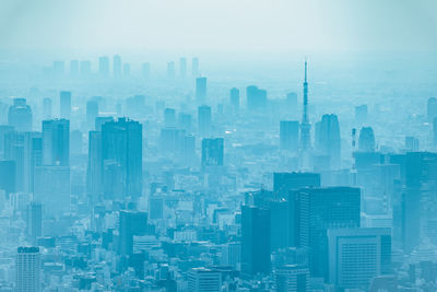 Aerial view of buildings in city against sky