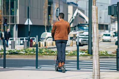 Rear view of man walking on sidewalk