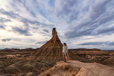 Rear view of man on rock formations against sky