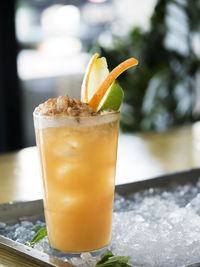 Close-up of lemonade garnish with fruits in glass on crushed ice