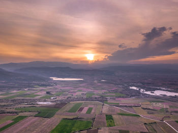 Scenic view of agricultural field against sky during sunset