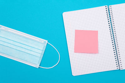 High angle view of open book on table against blue background
