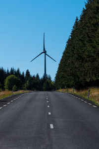 Road amidst trees against clear sky