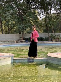 Portrait of woman standing by swimming pool