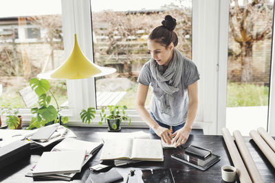 Female architect working at table in home office