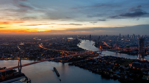 High angle view of illuminated cityscape against sky during sunset