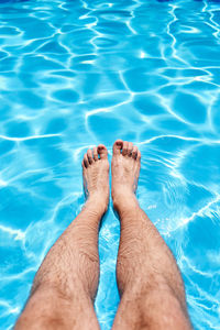 Low section of person legs in swimming pool