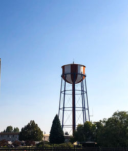 Low angle view of water tower against clear blue sky