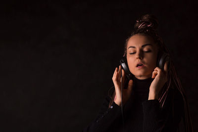 Portrait of a beautiful young woman over black background