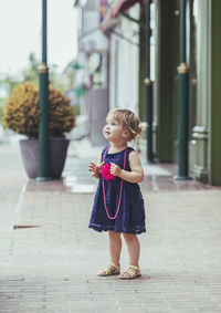 Beautiful baby girl in dress on the street