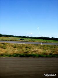 Scenic view of field against clear blue sky