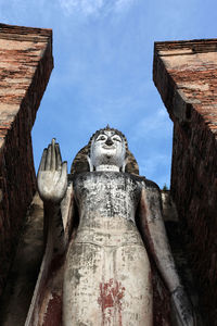 Low angle view of statues against sky