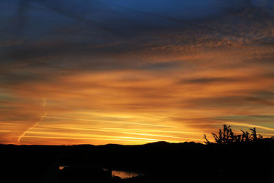 Silhouette landscape against scenic sky